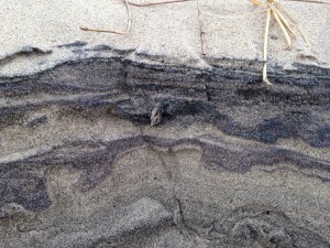 layers of sand revealed by waves