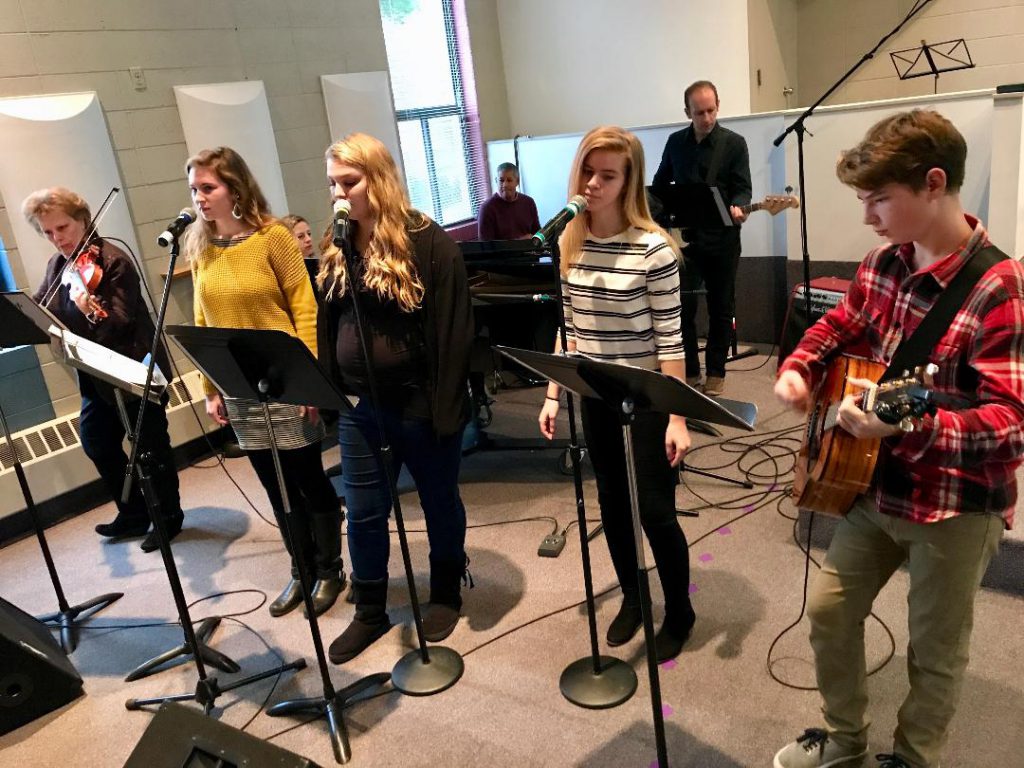 Four teenagers leading worship, plus some adult musicians backing them up.
