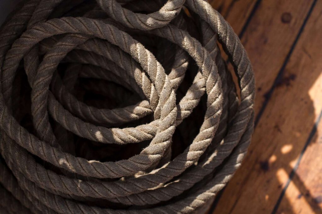 Photo by Andrew Castillo on Unsplash of coiled rope on a wooden floor